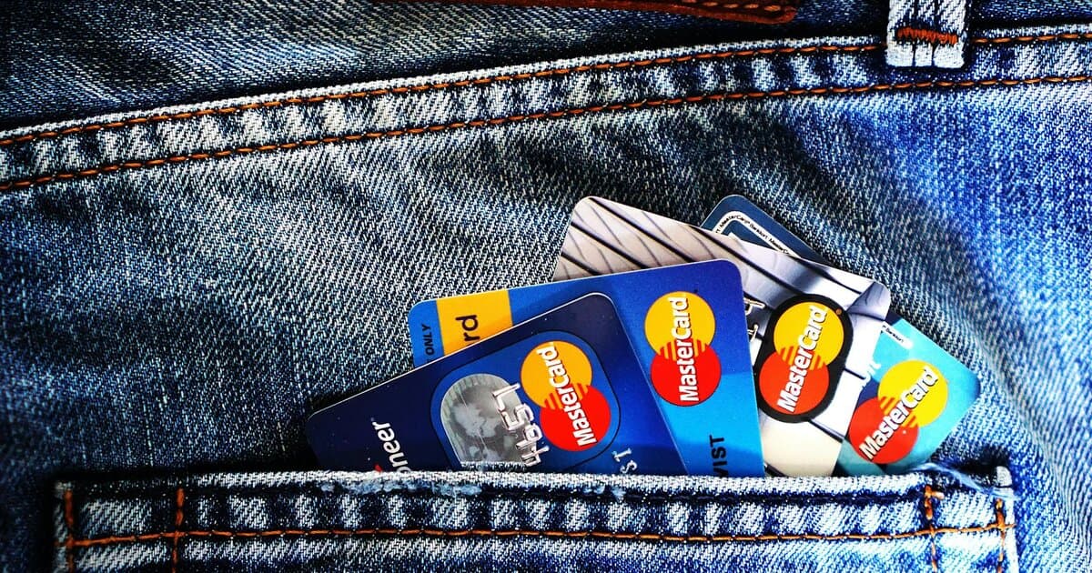 Close-up of a denim pocket with multiple credit cards, illustrating finance and fashion.