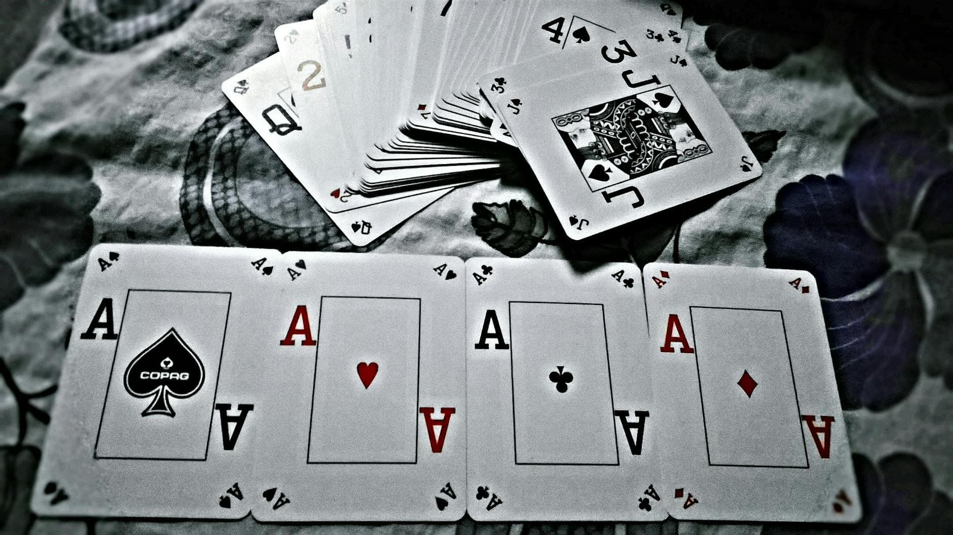 A close-up view of playing cards showing four aces, symbolizing a winning hand in poker.