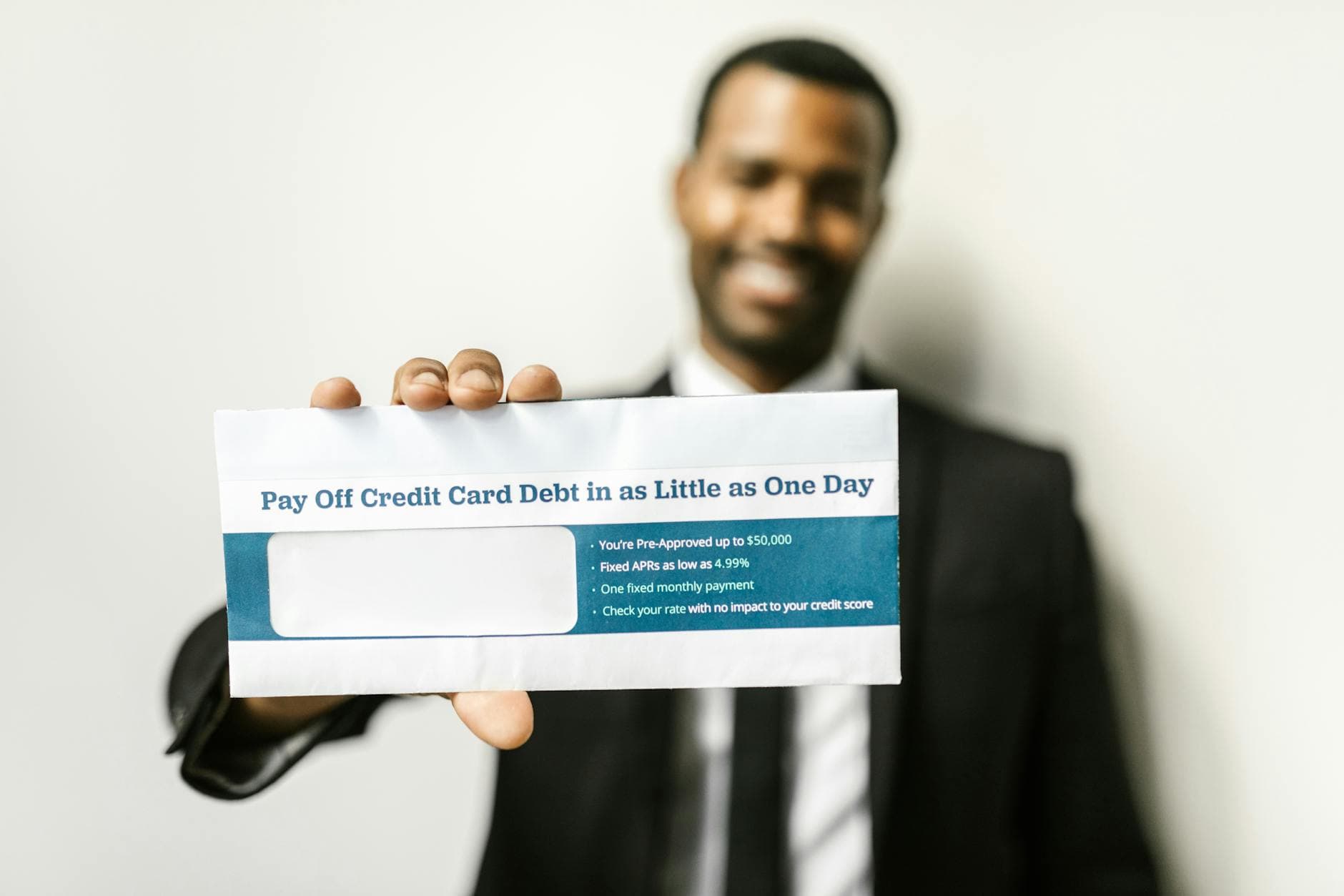 African American man holding envelope emphasizing credit card debt relief options.