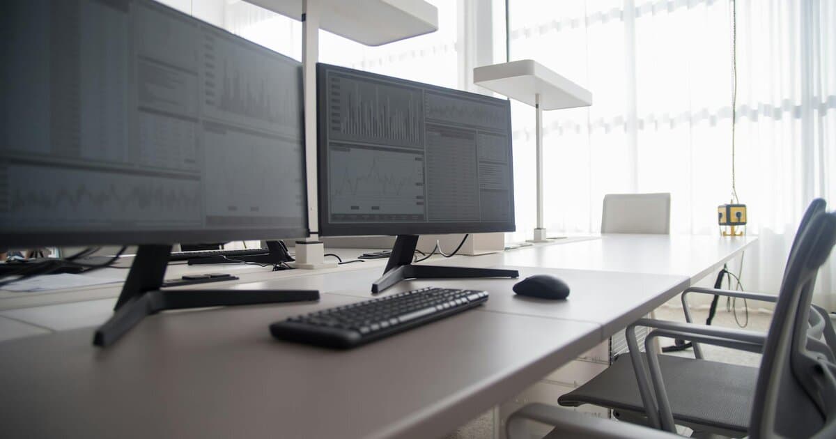 Stylish contemporary office featuring multiple computer monitors and ergonomic chairs.