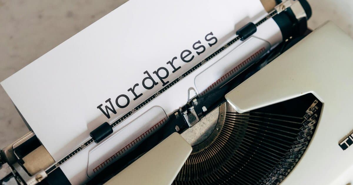 Close-up of a vintage typewriter with a paper displaying 'WordPress', ideal for blogging and writing concepts.