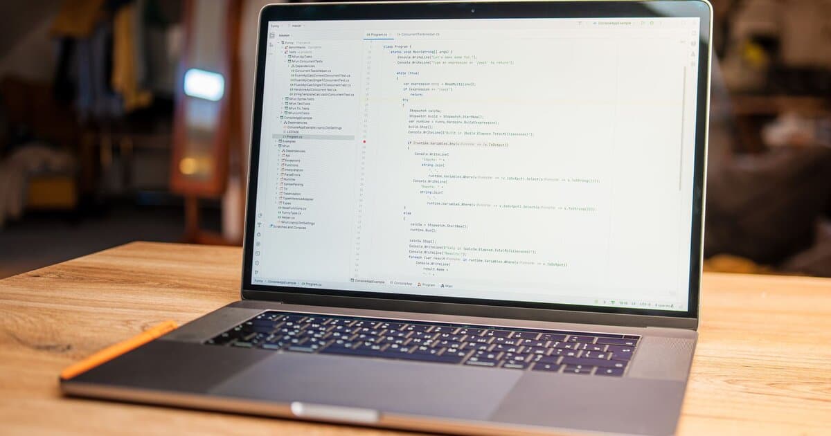 Open laptop with visible code on screen on a wooden desk in a modern, cozy workspace.