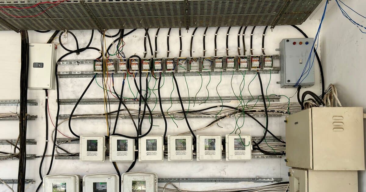Complex network of electrical wiring and control panels in an industrial setting.