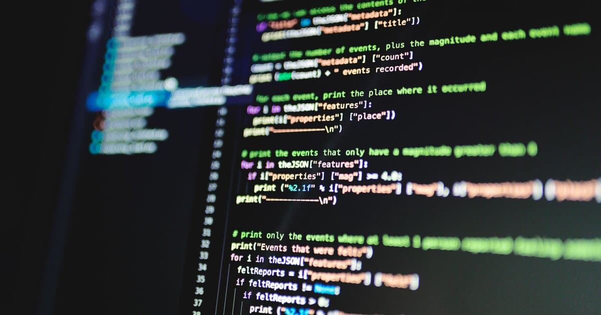 Close-up of colorful programming code displayed on a computer monitor with a dark background.